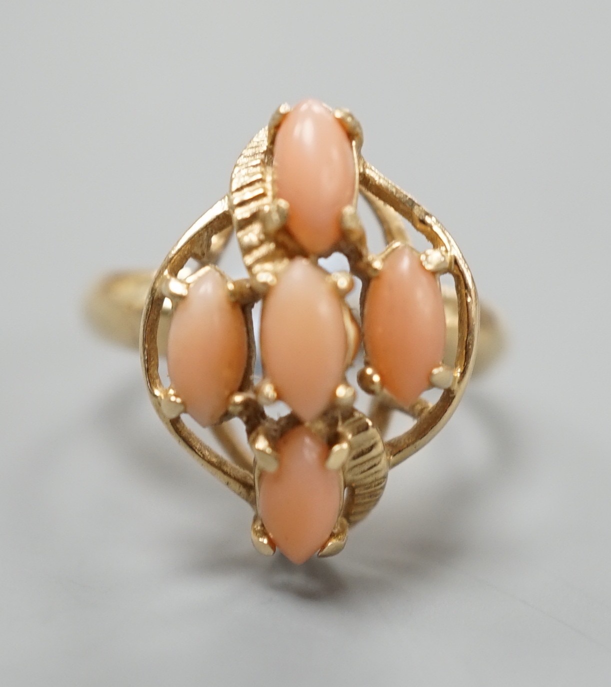 A modern 14k yellow metal and five stone oval coral bead set dress ring, size J/K, gross weight 2.9 grams.